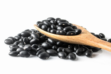Black beans isolated in wooden spoon on white background.