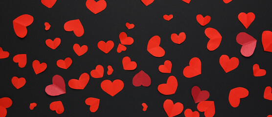 Fototapeta na wymiar Many little red hearts on a black background. Background for decor.Banner