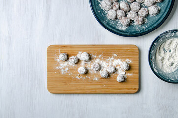 Round patties dipped in flour on a cutting board