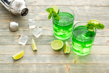 Glasses of iced mojito or lemonade with lime and mint