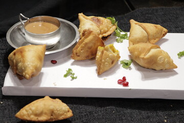 Assorted indian food set on wooden background. Dishes and appetisers of indeed cuisine, rice, lentils, paneer, samosa, spices, masala. Bowls and plates with indian food, 75