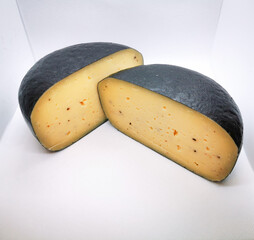 Wax-coated cheese wheel with truffles cut into two pieces picture taken in a lightbox