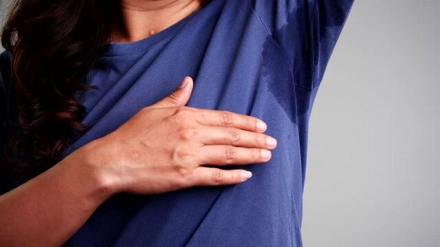 Close-up woman with hyperhidrosis sweating. Young asia woman with sweat stain on her clothes. Healthcare Concept.