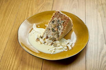 Appetizing waffle cake with condensed milk, custard and coconut chips. Delicious dessert. Wood...