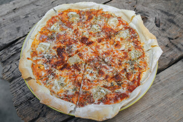 Top view Hawaiian Pizza in a white plate on a wooden table.