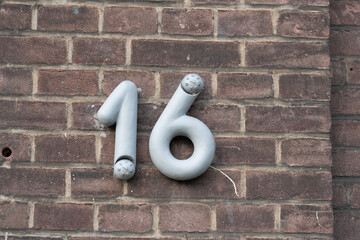 Number sixteen on a brick wall