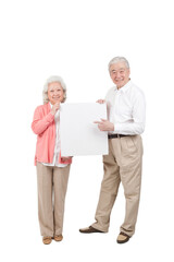 An old senior couple holding white board