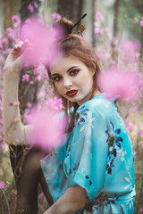 Japanese-style girl in a flowering forest among pink flowers in spring