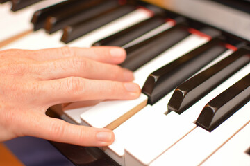 close up of a woman's hand on the piano with blurring in the background