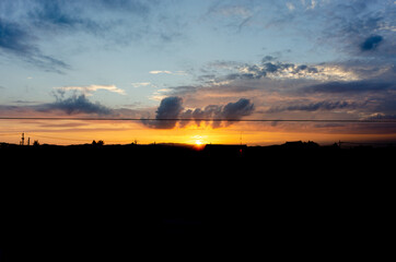 夕焼け空、町と電線のシルエット