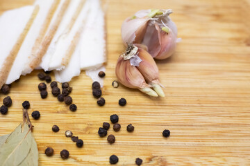 Garlic with pieces of bacon, isolated on a wooden table.