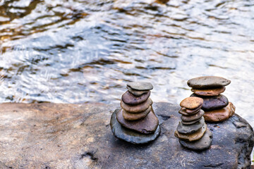 Fototapeta na wymiar Balanced Zen rock stacks in a creek,View of a creek with stacked stones on a rock