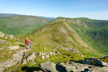 A female hiker walking off the summit of  Ill Bell towards Frosw