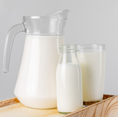 A jug and bottle of  fresh milk glass on wooden crate box..Raw milk is high in calcium and protein to drink for all ages..Milk consumption nutritious and healthy dairy products concept.