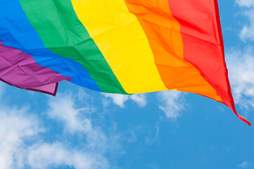Rainbow flag symbol and banner of LGBT people with blue sky, Equal rights conception.
