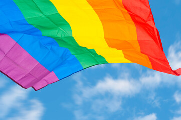 Rainbow flag symbol and banner of LGBT people with blue sky, Equal rights conception.