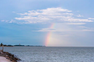 Rainbow on the sea with blue sky after raining.