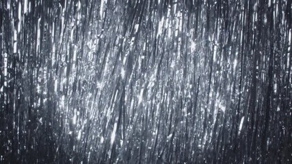 Silver tinsel rain on the background. A hand with a champagne glass appears in the spotlight. Another hand in a white glove serving sparkling wine. Confetti falling down. 4k high quality still shot
