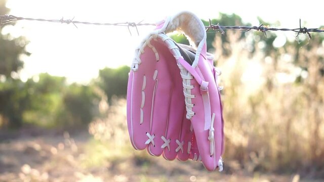 Footage Slow Motion: Softball glove hung on a barbed wire fence