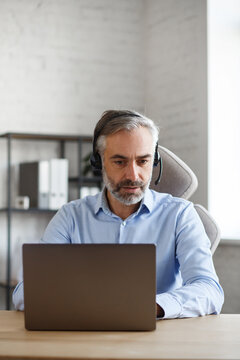 Online education, remote working, home education. Portrait of grey-haired senior handsome man teaching online. Online meeting, video call, video conference, courses online.