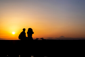 Fototapeta na wymiar 夕焼けの東京ゲートブリッジを眺めるカップルのシルエット