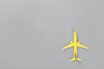 Gelbes Modell des Passagierflugzeugs auf ultimativer grauer Papierstruktur © photopixel