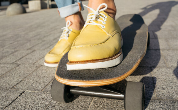 Man wearing stylish yellow shoes riding on skateboard 