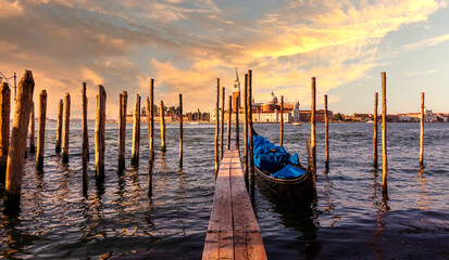 Beautiful seascape of Venice while sunset with gondola boat near by the pier in front of the basilica historical building by the ocean.  © Thipphawan