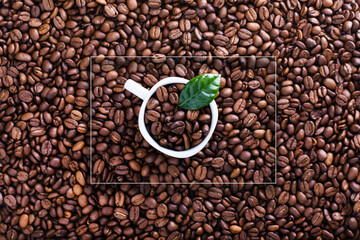 White cup on Roasted beans background with geometric frame