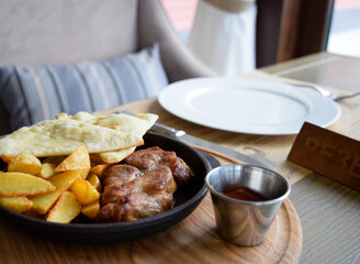 Breakfast with fried meat, chips and french fries