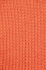 Orange knitted fabric texture background. Top view. Copy, empty space for text