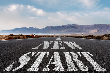 low angle view of words NEW START and arrow symbol painted on asphalt road, new beginning and...