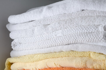 Folded stack of towels on a gray background. Household items.