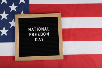 Fototapeta na wymiar black letter board with text national freedom day and American flag.