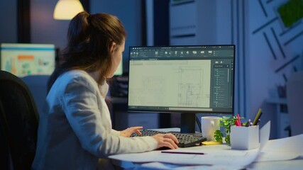 Woman architect matching digital plans from pc with blueprints working in start-up business office overtime. Designer using cad software to design a 3D concept of buildings creating late at night - Powered by Adobe