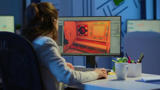 Woman game sotware developer testing new game overtime at night in start up creative agency company. Tired worker developing new online video games on pc with modern technology