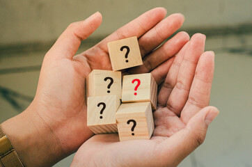 A wooden block on the hand of a business woman with a word mark icon (?) On it. And there is a red...