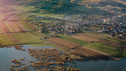 Aerial view over a village at the foot of the mountain and lake in scenery