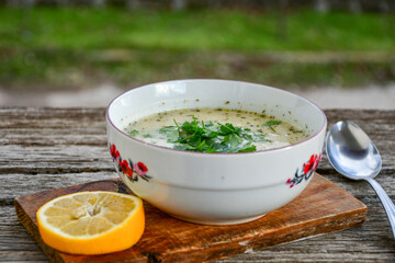 Home made chicken soup with noodles and vegetables in white bowl 