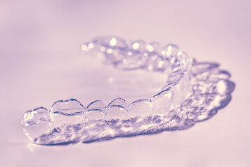 Invisible aligner teeth retainers on a pink background