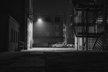 A parking lot at night, with light fog, industrial ambience, black and white photo