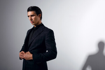 Obraz na płótnie Canvas Confident man in black stylish suit over white background.