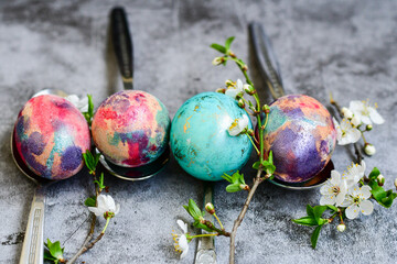 Colorful hand painted purple and rose  easter eggs and  spring blossom on wooden background
