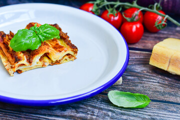 Lasagna bolognese and parmesan cheese  on a wooden rustic  background.Home made italian meal