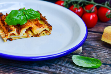 Lasagna bolognese and parmesan cheese  on a wooden rustic  background.Home made italian meal