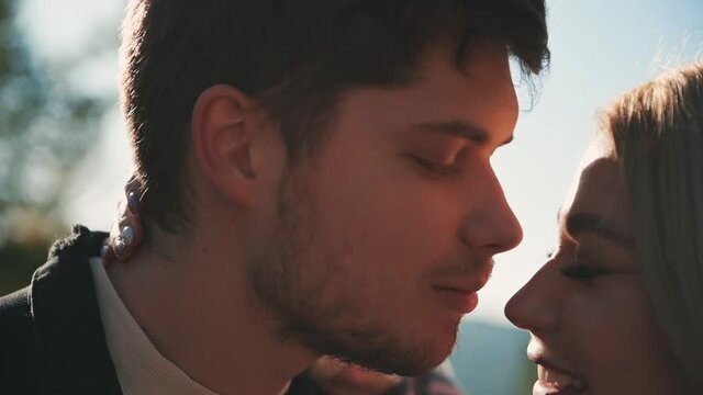 Portrait. Young man in love gives a kiss on the nose to his girlfriend. Young romantic couple. Close-up. Slow motion.
