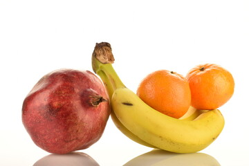 Two tangerines, three bananas and one pomegranate, close-up, isolated on white.
