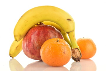 Two tangerines, three bananas and one pomegranate, close-up, isolated on white.