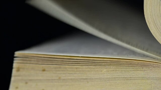 Man hand turning aged, old yellow book pages close up macro footage.