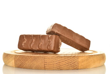Two sweet chocolate bars on a round wooden tray, close-up, isolated on white.
